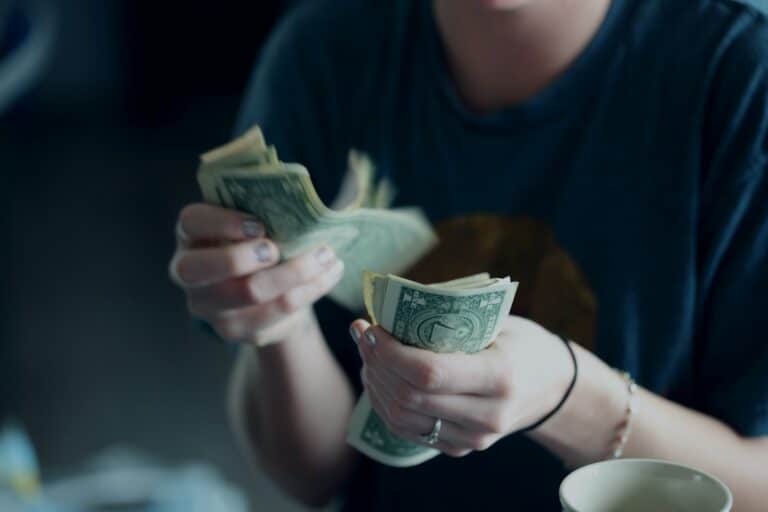 Persona contando los dolares que ha conseguido con su reclamación de gastos hipotecarios
